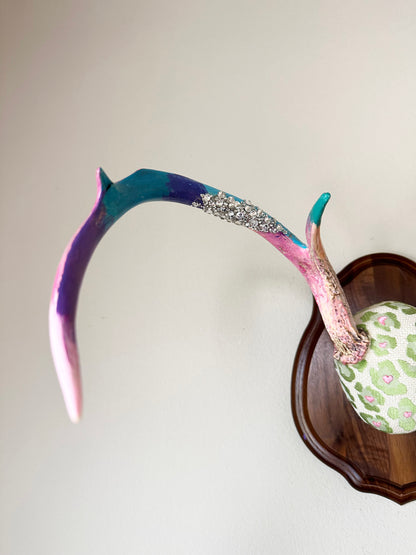 image of large real white tail deer antlers colorfully hand painted, mounted and covered in pastel neon green and pink cheetah leopard print fabric
